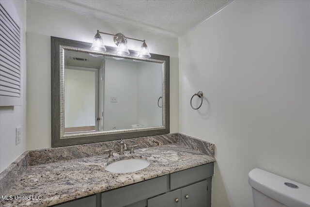 bathroom with visible vents, a textured ceiling, vanity, and toilet