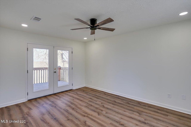 empty room with french doors, recessed lighting, visible vents, wood finished floors, and baseboards