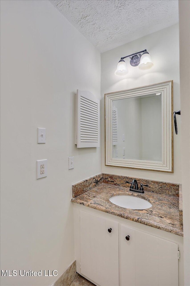 bathroom with a textured ceiling and vanity