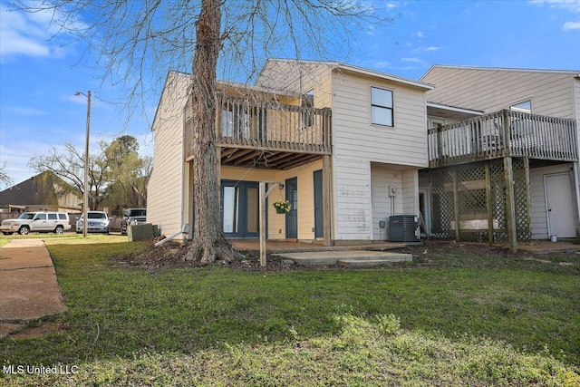 rear view of property with central air condition unit, a deck, a patio, and a yard