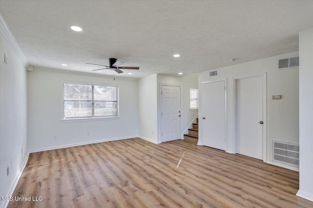 spare room featuring light wood-style floors and visible vents