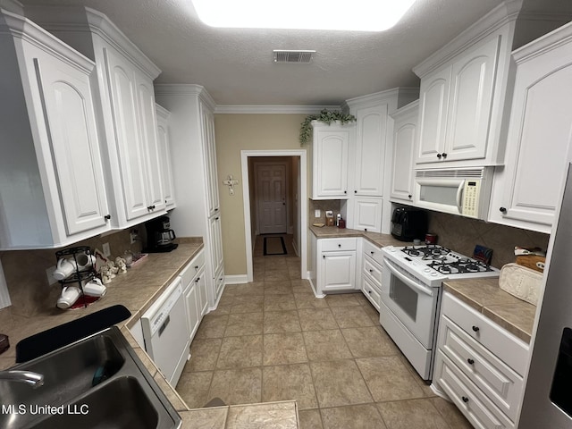 308 Barrington Cv, Byram, MS 39272 - kitchen featuring white appliances, a sink, decorative backsplash, and a textured ceiling