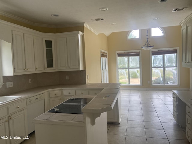 kitchen featuring tasteful backsplash, ornamental molding, light tile patterned floors, dishwasher, and tile counters