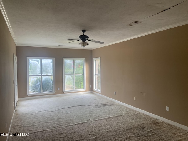 spare room featuring light carpet, a textured ceiling, ceiling fan, and ornamental molding