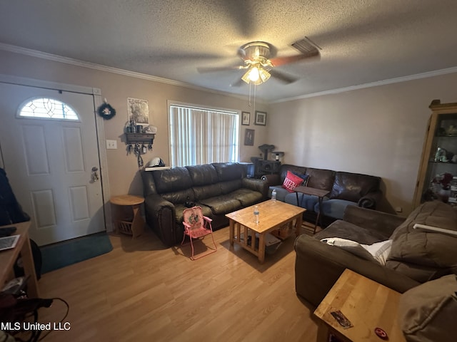 living room featuring hardwood / wood-style floors, crown molding, a textured ceiling, and ceiling fan