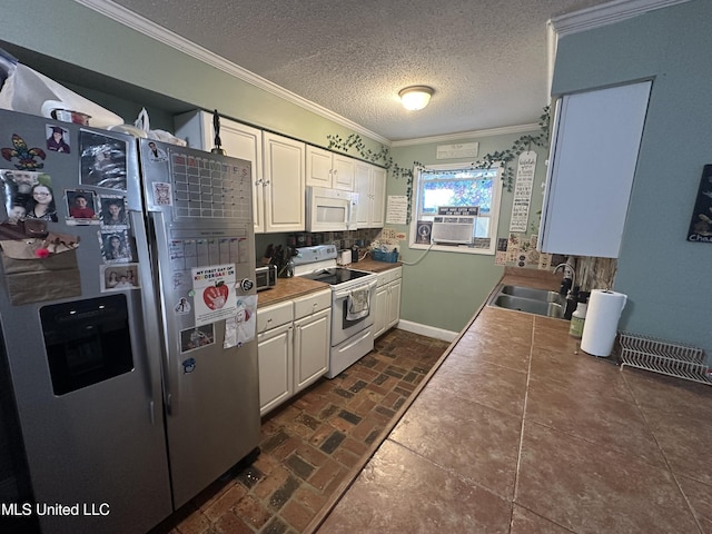 kitchen featuring sink, white cabinets, white appliances, crown molding, and a textured ceiling