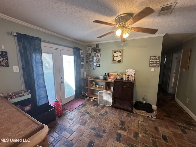 interior space with ornamental molding, ceiling fan, a textured ceiling, and french doors