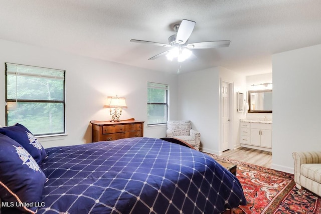 3109 Breezy Hill Ln, Ocean Springs, MS 39564 - bedroom with light wood-style floors, baseboards, ensuite bathroom, and ceiling fan