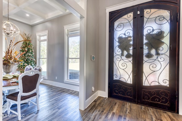 entryway featuring french doors, coffered ceiling, dark wood-type flooring, beam ceiling, and a chandelier