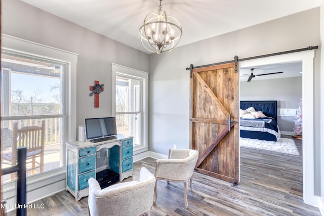 sitting room with a barn door, hardwood / wood-style floors, and plenty of natural light