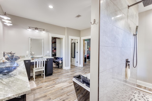 bathroom with hardwood / wood-style floors, vanity, and walk in shower