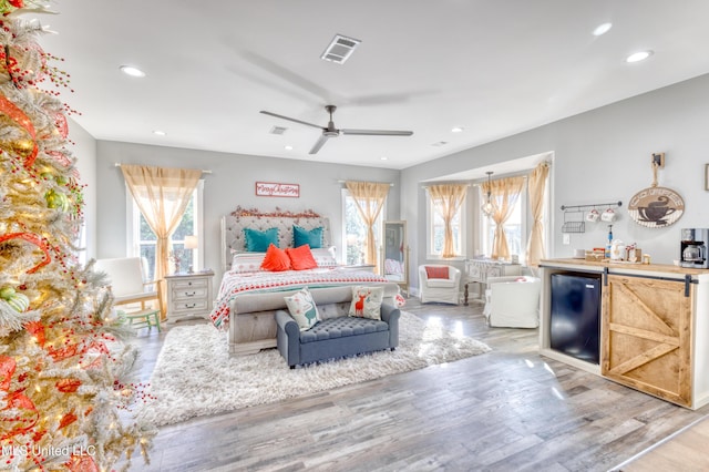 bedroom featuring ceiling fan, light hardwood / wood-style flooring, and fridge