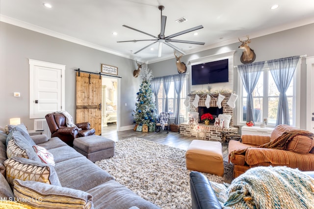 living room featuring a fireplace, hardwood / wood-style floors, ceiling fan, and a healthy amount of sunlight