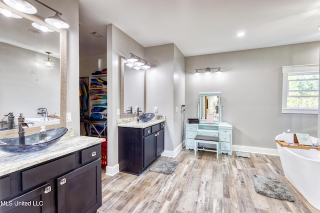 bathroom featuring a bathing tub, vanity, and wood-type flooring