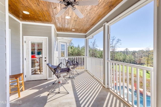 sunroom / solarium featuring a wealth of natural light, ceiling fan, and wood ceiling