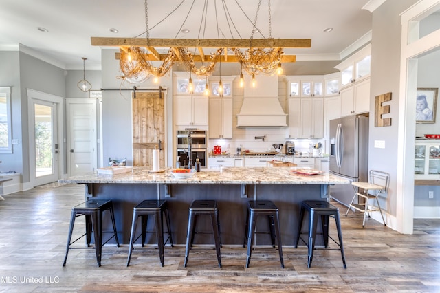 kitchen featuring pendant lighting, crown molding, appliances with stainless steel finishes, tasteful backsplash, and custom range hood