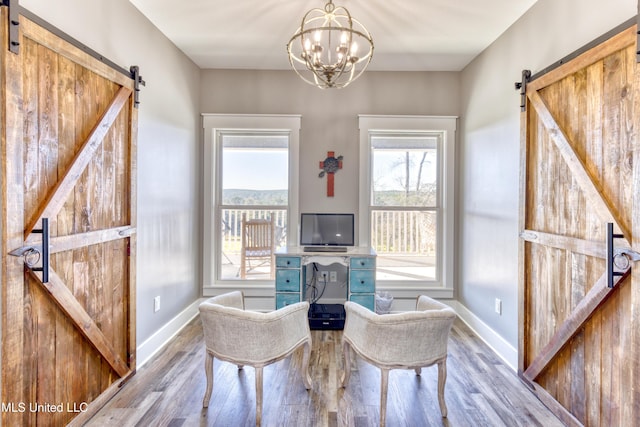 interior space featuring hardwood / wood-style floors, a barn door, and an inviting chandelier