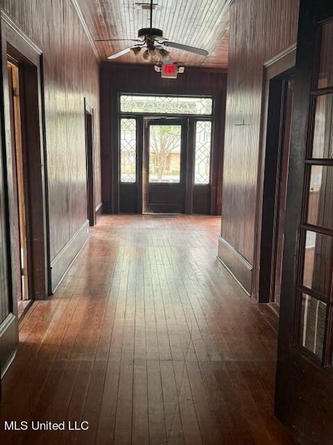 hall with wood ceiling, hardwood / wood-style floors, and wooden walls