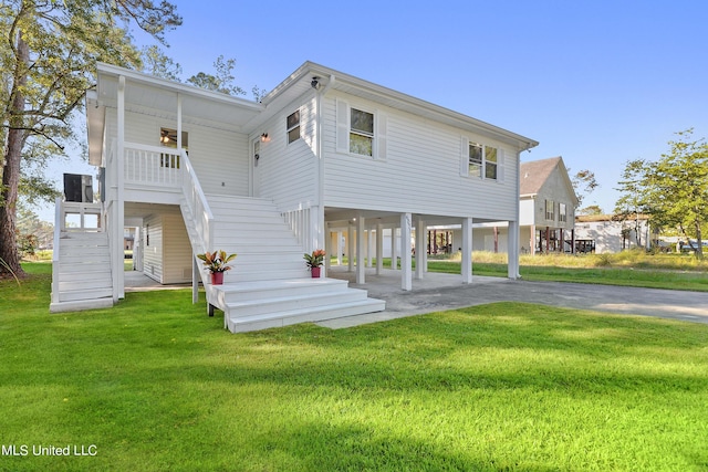 6071 Comanche St, Kiln, MS 39556 - rear view of house featuring a carport, stairway, a yard, and asphalt driveway