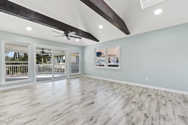 unfurnished living room featuring light wood-type flooring, ceiling fan, and lofted ceiling with skylight