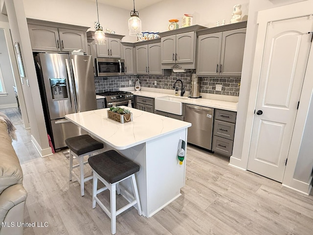 2290 Loisy Blvd, Hernando, MS 38632 - kitchen featuring appliances with stainless steel finishes, a sink, gray cabinetry, and light wood-style floors