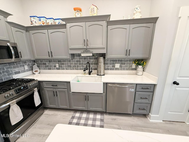 2290 Loisy Blvd, Hernando, MS 38632 - kitchen with appliances with stainless steel finishes, gray cabinetry, a sink, and light wood finished floors