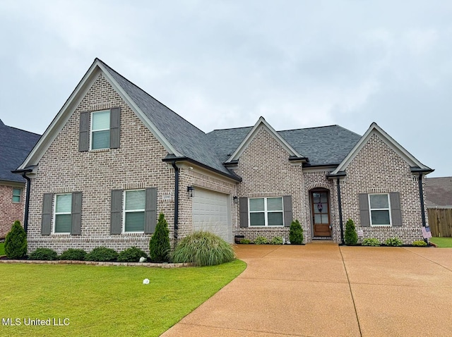2290 Loisy Blvd, Hernando, MS 38632 - view of front of property with brick siding, driveway, a front yard, roof with shingles, and an attached garage