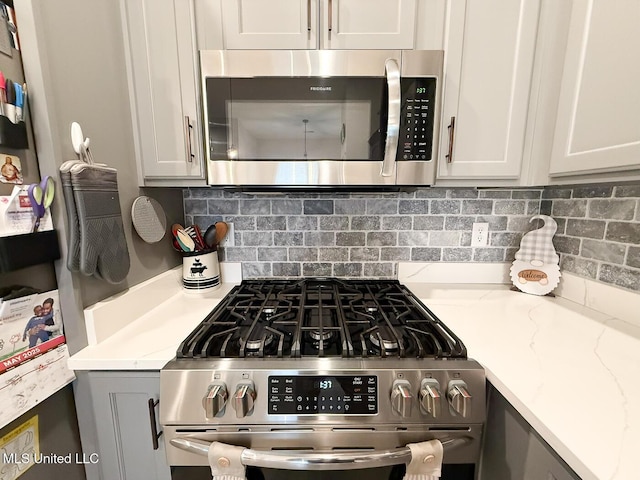 2290 Loisy Blvd, Hernando, MS 38632 - kitchen with stainless steel appliances, white cabinets, light stone countertops, and tasteful backsplash