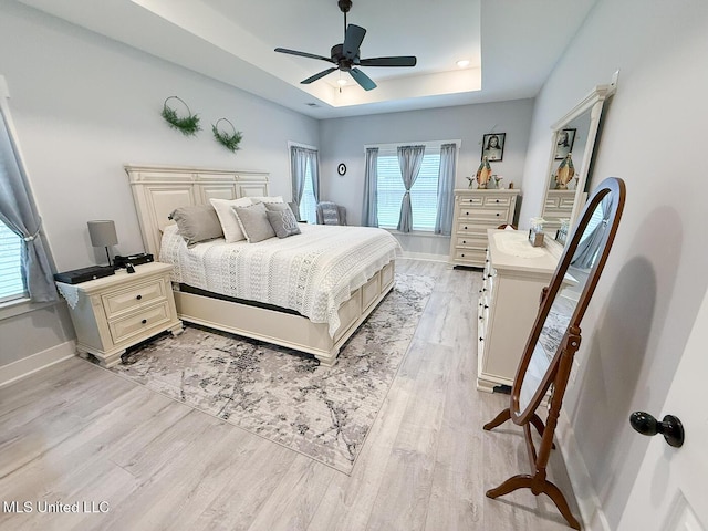 2290 Loisy Blvd, Hernando, MS 38632 - bedroom featuring light wood-style flooring, multiple windows, a tray ceiling, and baseboards
