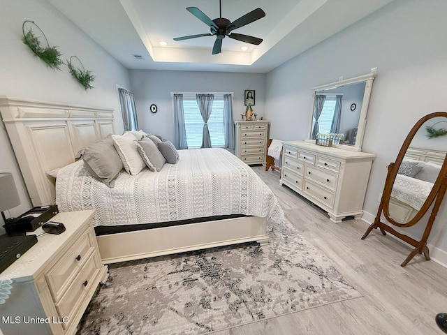 2290 Loisy Blvd, Hernando, MS 38632 - bedroom featuring light wood-style flooring, a tray ceiling, baseboards, and ceiling fan