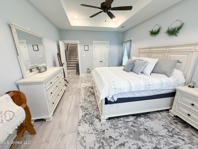 2290 Loisy Blvd, Hernando, MS 38632 - bedroom featuring a tray ceiling, light wood finished floors, a ceiling fan, and baseboards