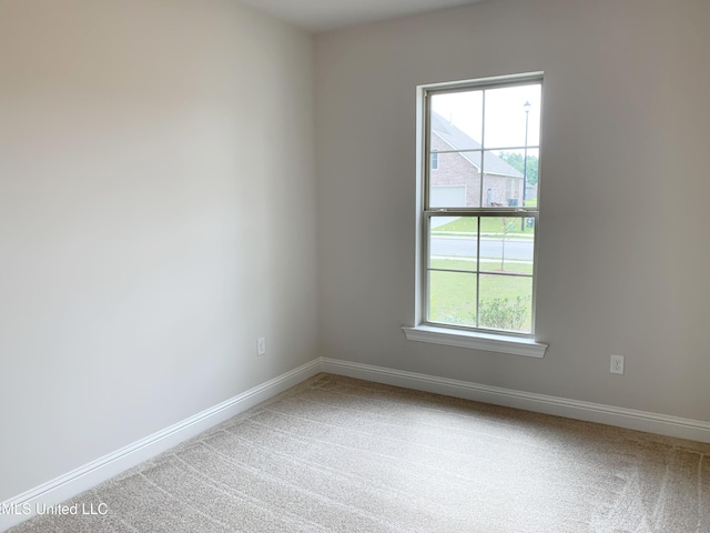 empty room with carpet and baseboards