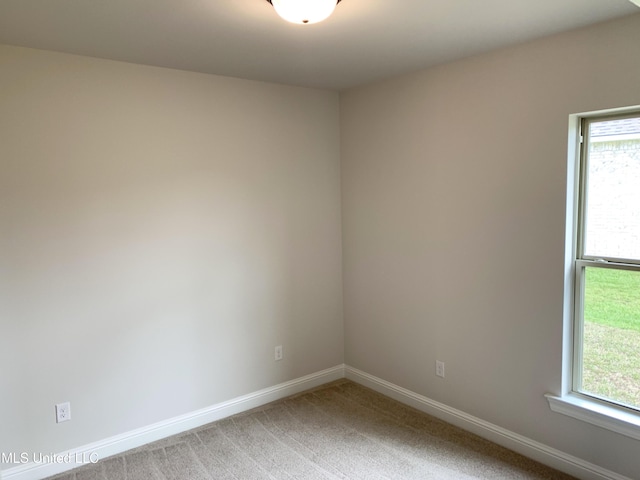 unfurnished room with baseboards and light carpet