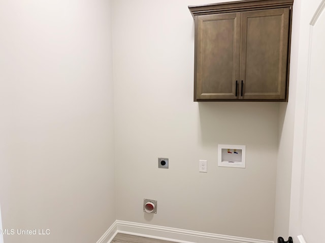 washroom featuring hookup for an electric dryer, cabinet space, hookup for a washing machine, baseboards, and wood finished floors
