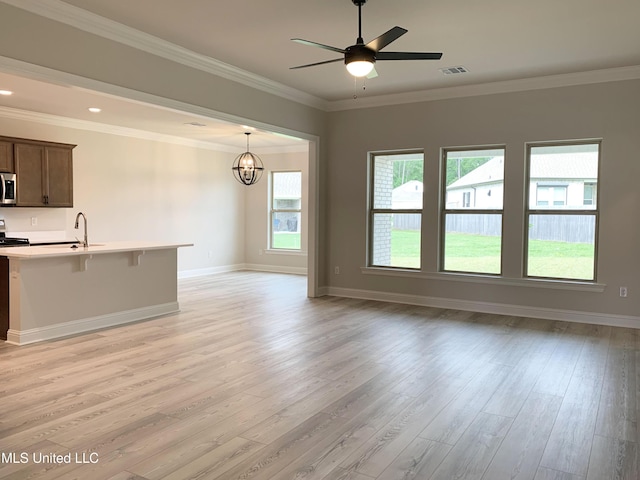 unfurnished living room featuring a sink, visible vents, baseboards, light wood-type flooring, and ceiling fan with notable chandelier