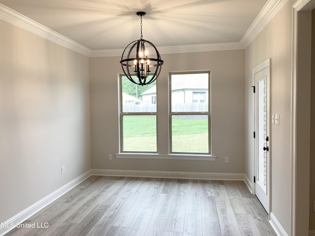 interior space with ornamental molding, light wood-style flooring, a chandelier, and a healthy amount of sunlight
