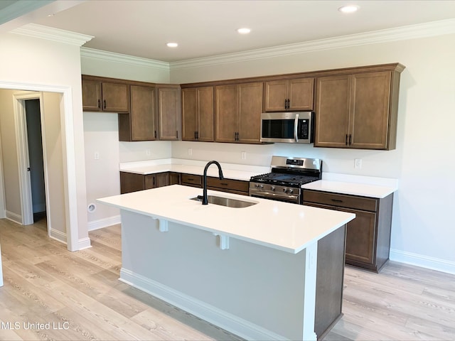 kitchen with stainless steel appliances, baseboards, light wood-style flooring, and a sink
