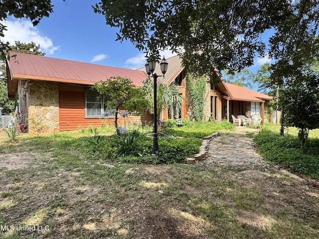 5114 Bay St, Pascagoula, MS 39567 - view of side of property with stone siding and metal roof