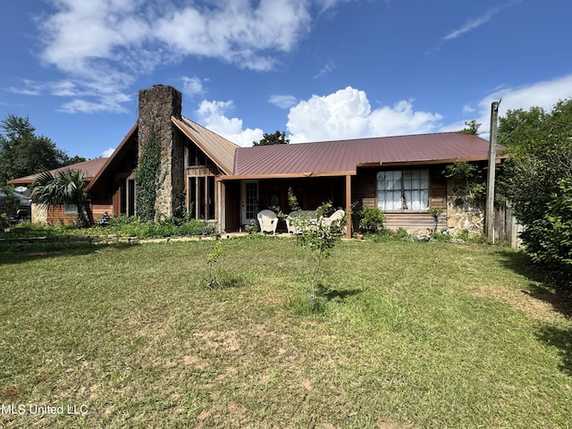 5114 Bay St, Pascagoula, MS 39567 - back of property featuring a yard, a chimney, metal roof, and stone siding