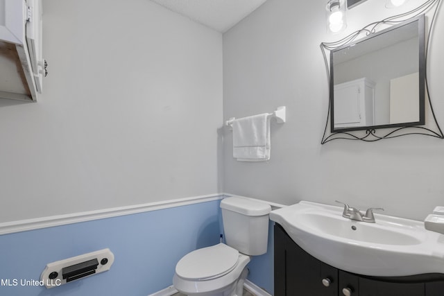 bathroom featuring vanity, toilet, and a textured ceiling