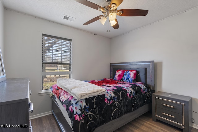 bedroom featuring dark wood-type flooring, ceiling fan, and a textured ceiling