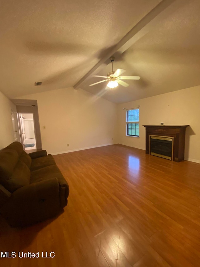 living room with ceiling fan, lofted ceiling with beams, a textured ceiling, and hardwood / wood-style floors