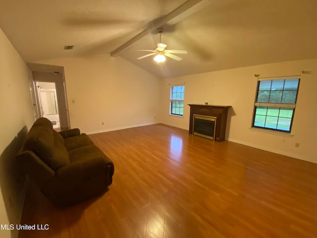 living room featuring ceiling fan, hardwood / wood-style flooring, a wealth of natural light, and vaulted ceiling with beams