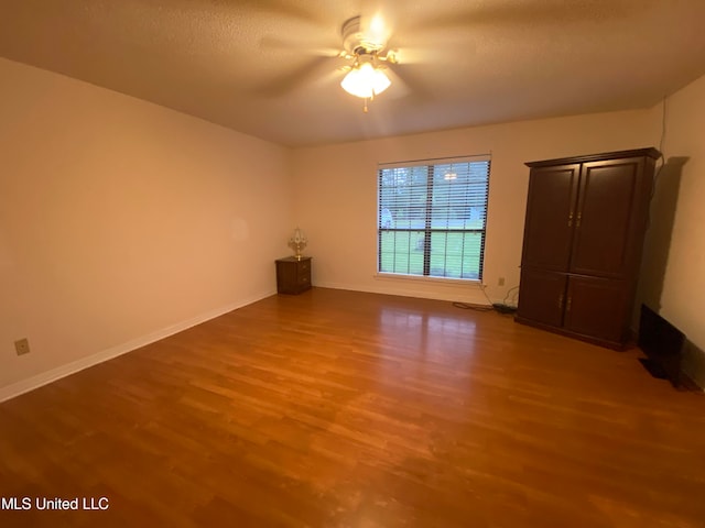 interior space with ceiling fan, a textured ceiling, and hardwood / wood-style floors