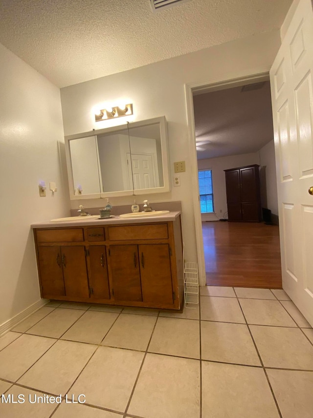 bathroom featuring vanity, a textured ceiling, and tile patterned floors