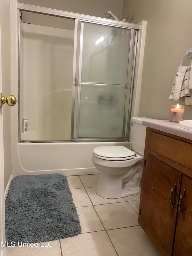 full bathroom with vanity, combined bath / shower with glass door, toilet, and tile patterned flooring