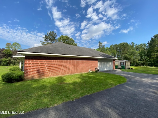 view of side of home featuring a yard and a garage