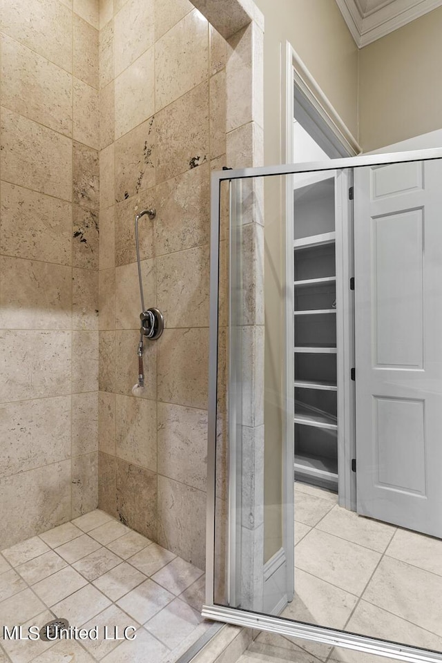 bathroom with ornamental molding and tiled shower