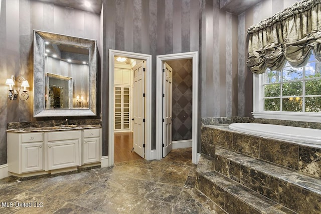 bathroom with a relaxing tiled tub and vanity