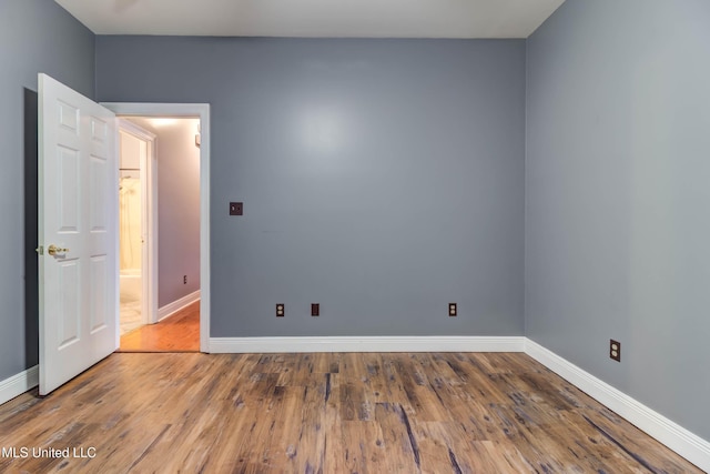 unfurnished room featuring baseboards and wood finished floors